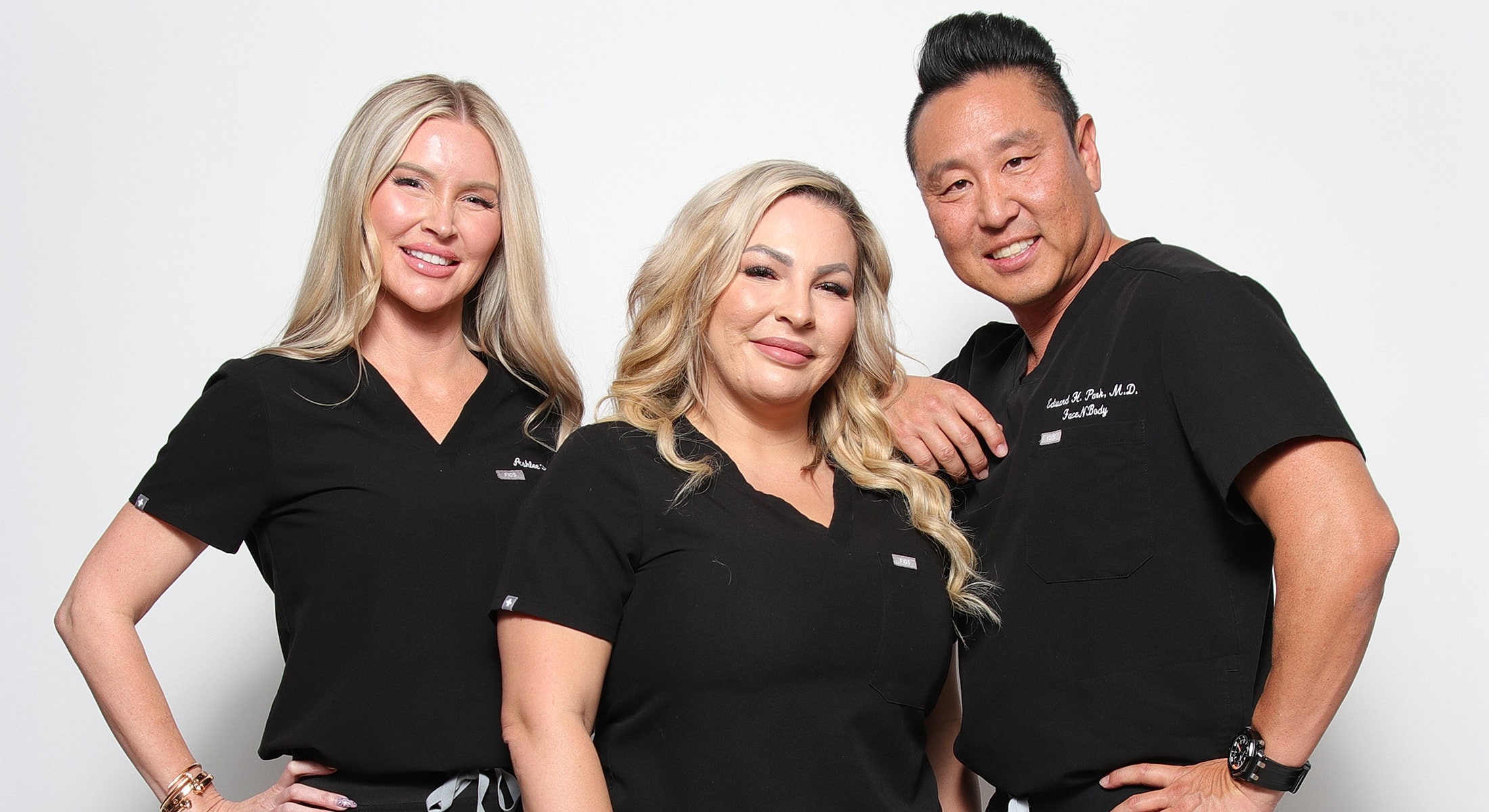 Three healthcare professionals smiling together.